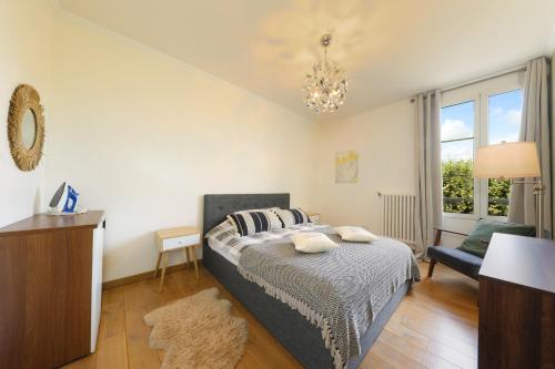 a bedroom with a bed and a chair and a window at Charmant Appartement dans le centre ville, à 2 minutes du Palais in Compiègne
