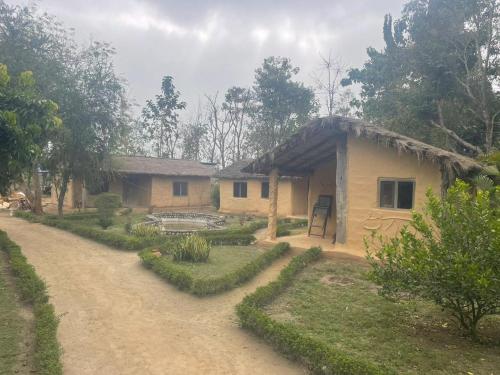 ein Haus mit einer Schotterstraße davor in der Unterkunft Bardia dolphin home in Bhurkīā