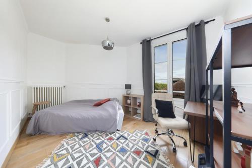 a bedroom with a bed and a desk and window at Charmant Appartement dans le centre ville, à 2 minutes du Palais in Compiègne
