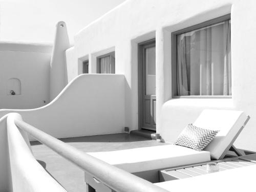 a white room with a couch and a window at San Marino Suites by Calm Collection in Fira