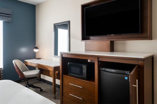 a hotel room with a flat screen tv and a desk at Courtyard by Marriott Seattle SeaTac Airport in Seattle