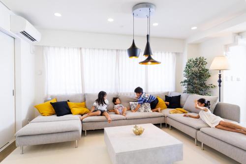 a family sitting on a couch in a living room at Walk to Asakusa, Sky tree MAX16P in Tokyo