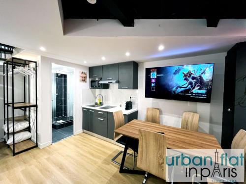 une cuisine et une salle à manger avec une télévision murale dans l'établissement Urban Flat 179 - Pretty Loft Montorgueil, à Paris