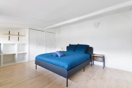 a bedroom with a blue bed in a white room at Appartement Quartier Place de la Bastille Free Netflix in Paris