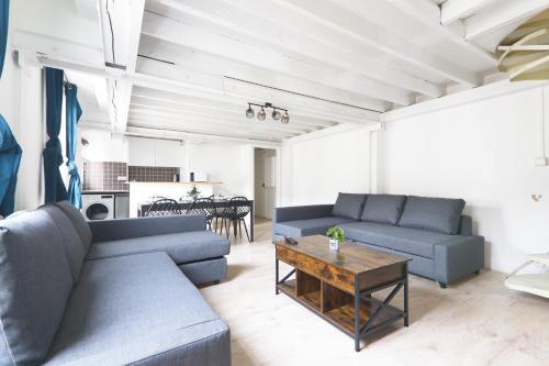 un salon avec deux canapés bleus et une table dans l'établissement Appartement Quartier Place de la Bastille Free Netflix, à Paris