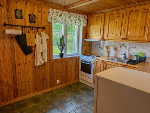 a kitchen with wooden cabinets and a sink and a stove at Stugan in Ekshärad