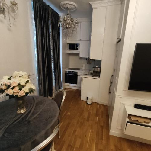 une table de salle à manger avec un vase de fleurs dessus dans l'établissement Cosy Flat 8e Champs-Elysées, à Paris