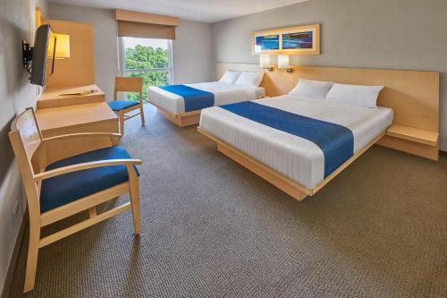 a hotel room with two beds and a chair at City Express by Marriott Apizaco in Apizaco