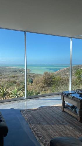 a living room with a view of the ocean at La Maison Bleue, luxury self-catering villa. in Langebaan