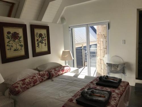a bedroom with a bed and a large window at La Maison Bleue, luxury self-catering villa. in Langebaan