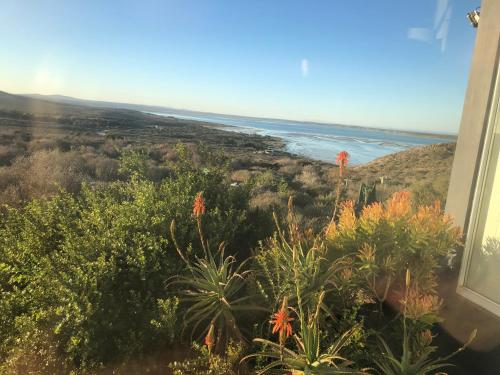 a view of the ocean from the balcony of a house at La Maison Bleue, luxury self-catering villa. in Langebaan