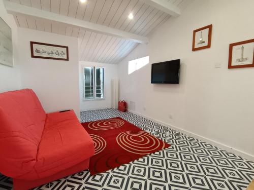 a living room with a red couch and a carpet at Danaé 1 in Saint-Martin-de-Ré