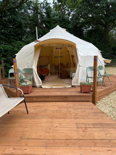 a white tent with chairs and a table in it at The Lily Pad Off Grid in Kingham