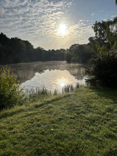 a view of a river with the sun in the background at The Lily Pad Off Grid in Kingham