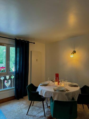 une salle à manger avec une table et des chaises et une fenêtre dans l'établissement Le Petit Social Home, à Chamonix-Mont-Blanc