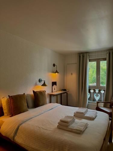 une chambre avec un grand lit avec des serviettes dessus dans l'établissement Le Petit Social Home, à Chamonix-Mont-Blanc
