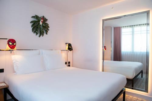 a hotel room with two beds and a mirror at Mama Shelter Lisboa in Lisbon