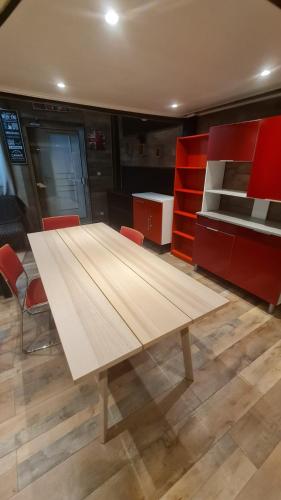 Cette chambre comprend une grande table en bois et des armoires rouges. dans l'établissement Loft avec 1H d'accès piscine spa, à Dijon