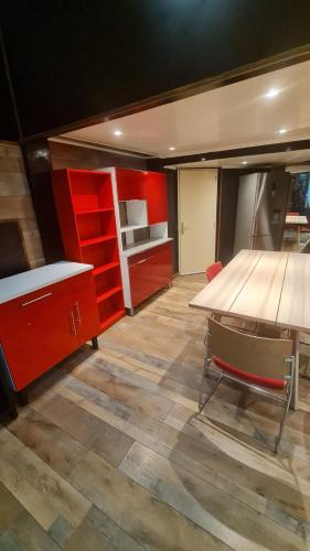 Cette chambre comprend un bureau, une table et des armoires rouges. dans l'établissement Loft avec 1H d'accès piscine spa, à Dijon