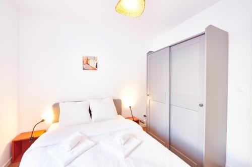 une chambre avec un lit blanc et un placard dans l'établissement RT 0 - Charmant F3 - au RDC - 1 à 5 pers, à Mulhouse