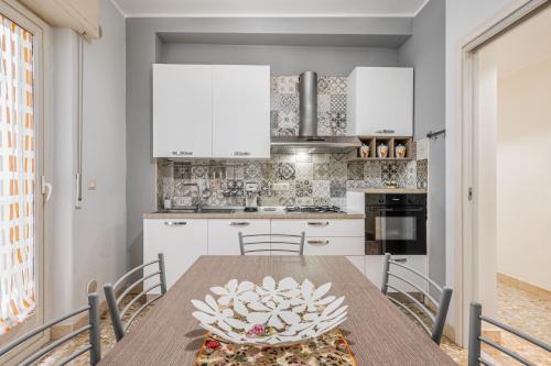 a kitchen with a wooden table and chairs at Charming Apartment Near Villa Bellini in Catania in Cibali