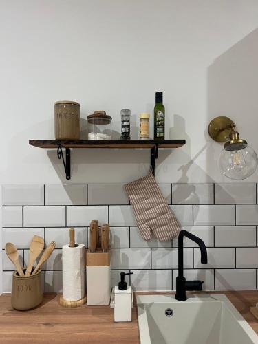 Il comprend une cuisine avec un évier et un mur carrelé blanc. dans l'établissement By Homy, à Bordeaux