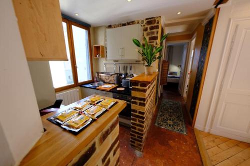 - une cuisine avec un comptoir et une table avec de la nourriture dans l'établissement Rouen Hôtel de Ville - Chez Eric, à Rouen