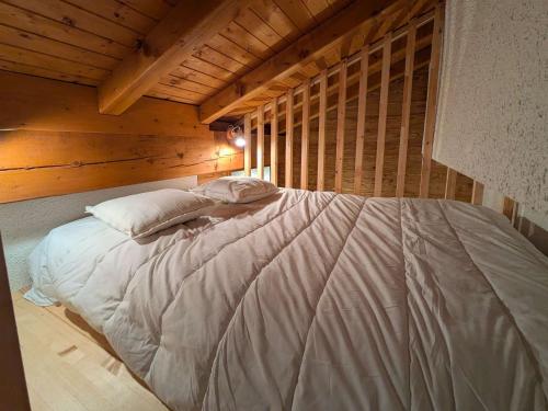 Cette chambre en bois comprend un grand lit blanc. dans l'établissement Appartement confortable au cœur du village, 6 pers, proche remontées mécaniques, piscine privée en été - FR-1-342-317, à Beaufort