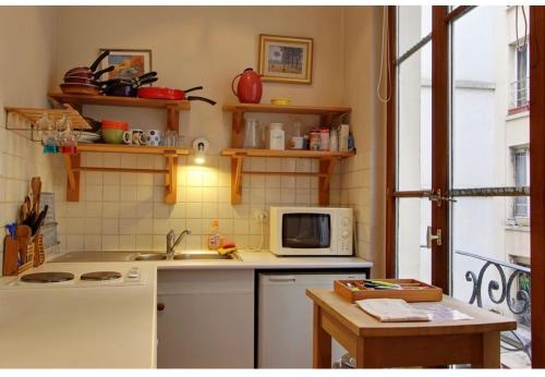 une cuisine avec un évier et un micro-ondes dans l'établissement Studio convivial à Paris, 30 m² avec vue sur la ville, à Paris