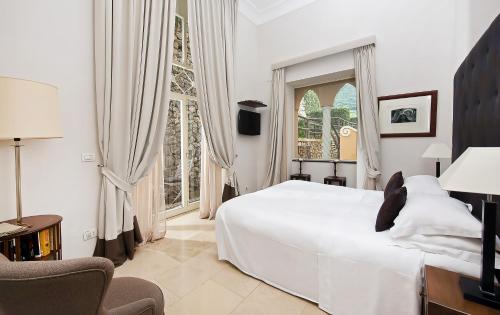 a bedroom with a large white bed and a window at Villa Marina Capri in Capri