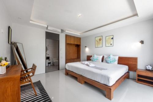 a bedroom with a bed and a desk and a bed sidx sidx sidx at 宽敞舒适 邦涛海滩Laguna附近 四卧室私人泳池别墅 V07 in Phuket Town