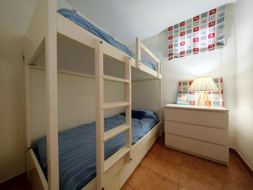 a bedroom with a bunk bed and a desk at Gladiolos San Agustin Beach in San Agustin