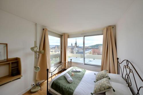 une chambre avec un lit et une grande fenêtre dans l'établissement Rouen Hypercentre - Seine en vue, à Rouen