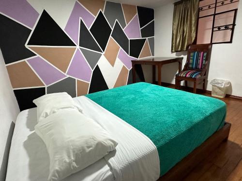 a bedroom with a bed with a colorful wall at El Jardín Escondido by Soma in Baños