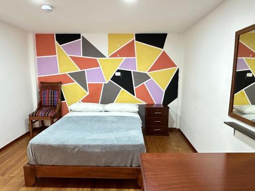 a bedroom with a bed with a colorful wall at El Jardín Escondido by Soma in Baños