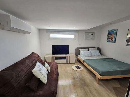 un salon avec un canapé et un lit dans l'établissement Studio proche de la mer, à Hyères