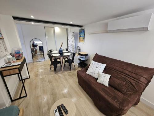un salon avec un canapé marron et une table dans l'établissement Studio proche de la mer, à Hyères