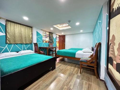 a bedroom with two beds and a table and chairs at El Jardín Escondido by Soma in Baños