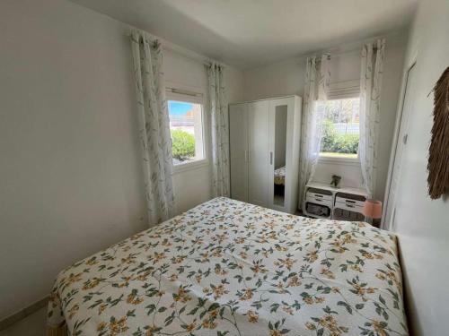 une chambre avec un lit et deux fenêtres dans l'établissement 2 pièces en rez-de-villa avec beau jardin près plage, à Hyères