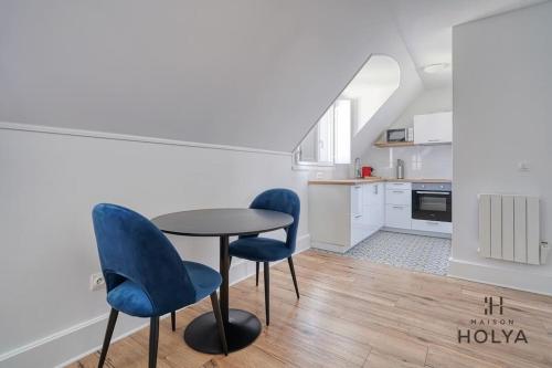 une cuisine avec une table et deux chaises bleues dans l'établissement Le Saphir - Proche Château de Versailles - 346B, à Versailles
