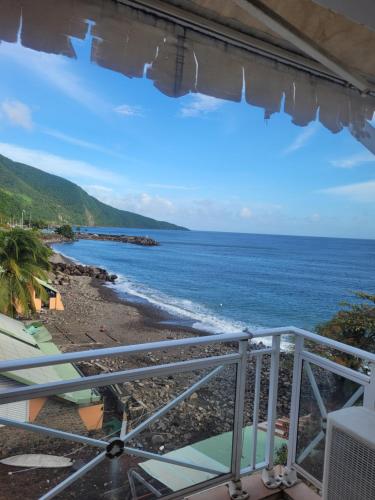 a view of the beach from a balcony at Location studio vue exceptionnelle proximité mer in Gourbeyre