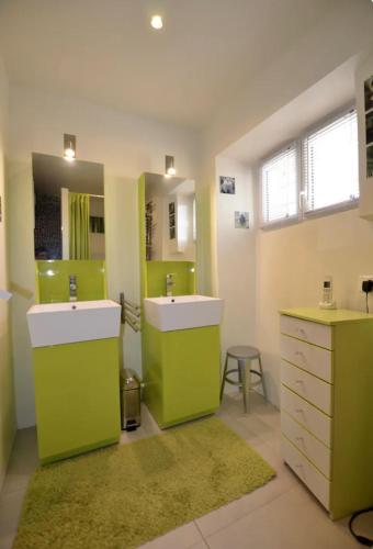 une salle de bain avec deux lavabos et un miroir dans l'établissement La salamandre, à Venterol