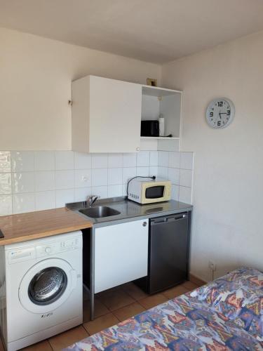 a kitchen with a sink and a washing machine at Location studio vue exceptionnelle proximité mer in Gourbeyre