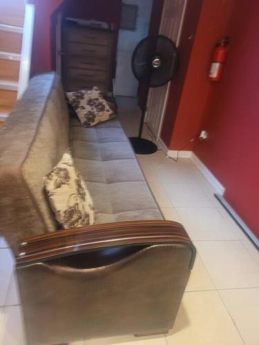 a couch in a living room with two pillows on it at The Garden Level MagicStudio in Cambria Heights
