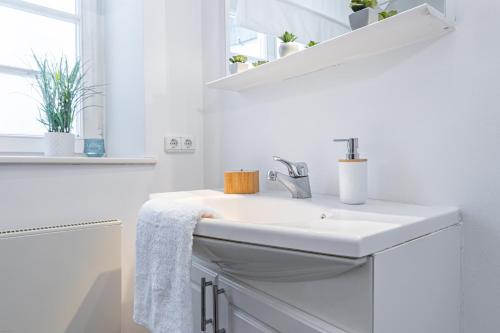 a white bathroom with a sink and a mirror at SMS-Homes I Auszeit in der Altstadt in Landsberg am Lech