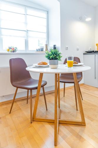 a table with two chairs and a plate of food on it at SMS-Homes I Auszeit in der Altstadt in Landsberg am Lech