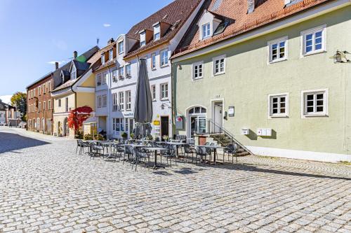 a cobblestone street with tables and chairs and buildings at SMS-Homes I Auszeit in der Altstadt in Landsberg am Lech