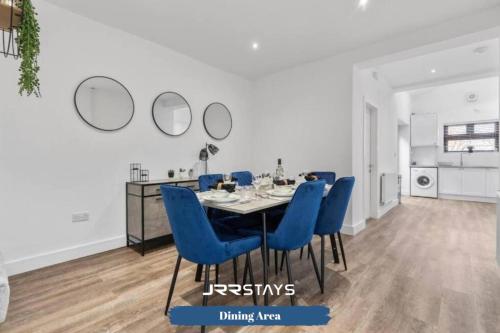 a dining room with a table and blue chairs at Burton on Trent - 3 Bedroom, Sleep 7, Wi-Fi - JRR Stays in Burton upon Trent