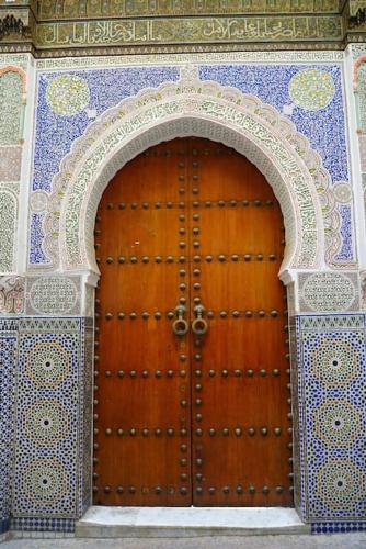 a wooden door with an arch in a building at Nabiloc Apart Hotel - Centre Ville in Fez