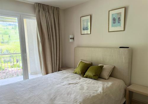 a bedroom with a bed with two green pillows at Hôtel des Bains de Saillon in Saillon